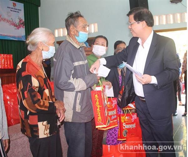 Ông Nguyễn Tấn Tuân - Phó Bí thư Tỉnh ủy, Chủ tịch UBND tỉnh (bìa phải) trao tặng quà cho người dân.